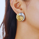 Brinco Anita, aço inoxidável, bicolor dourado e prateado com textura em espiral.